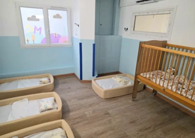 Photo de la salle de repos de la micro crèche de Juvisy-sur-Orge avec des petits lits au sol et un lit à barreau en bois